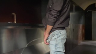 Man pist in het toilet en speelt met zijn pis