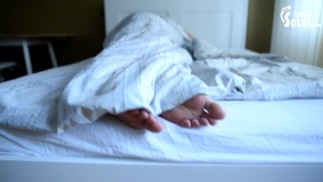 Girl's bare feet in bed
